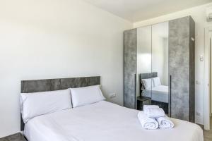 a bedroom with a white bed with towels on it at Giuliano Superior 4 personas in Empuriabrava +13 photos