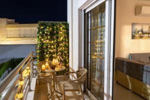 a table and chairs on a balcony with a christmas tree at Christina's House in Afantou