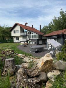 a house with a picnic table and rocks in the yard at Venero - Apartmani in Dubrave Gornje