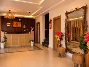 a lobby with a mirror and chairs and flowers at Hotel Valna Estate Himalyan View Kausani By HRG in Kausani