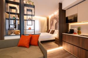 a hotel room with a bed and a couch with orange pillows at Residence Lido di Dante in Lido di Jesolo