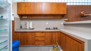 a kitchen with wooden cabinets and a sink at Alingga Cottage in Ubud