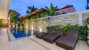 a house with a swimming pool with two chairs next to it at Alingga Cottage in Ubud