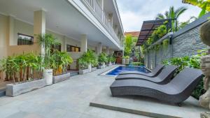a courtyard of a house with benches and plants at Alingga Cottage in Ubud