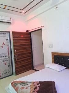 a room with a bed and a door and a sign at Khaatuwaale Guest House in Khātu