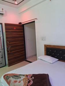 a bedroom with a bed and a wooden door at Khaatuwaale Guest House in Khātu