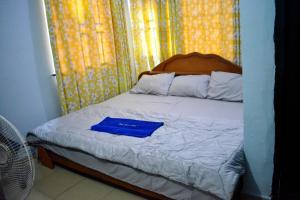 a bed with a blue folder on top of it at Jeks Apartments Limited in Ogbunike