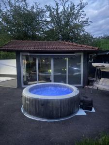 a large hot tub in front of a house at Venero - Apartmani in Dubrave Gornje