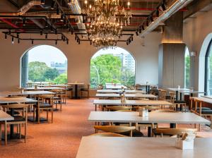 a row of tables and chairs in a room with windows at Staz Hotel Heritage in Jeju