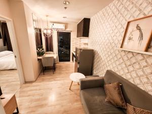 a living room with a couch and a dining room at The Room Bangyai in Ban Bang Krabu