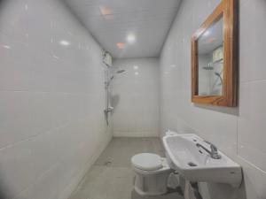 a white bathroom with a toilet and a sink at The sonteng hills in Sengkol