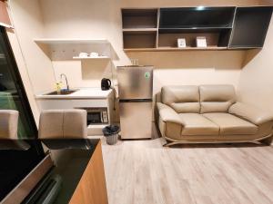 a small kitchen with a couch and a refrigerator at The Room Bangyai in Ban Bang Krabu +10 photos