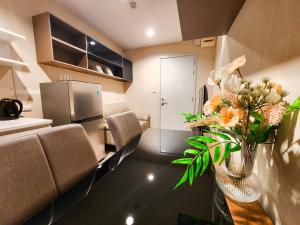 a kitchen with a vase of flowers on a table at The Room Bangyai in Ban Bang Krabu