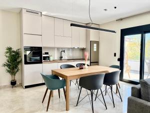 a kitchen and dining room with a wooden table and chairs at Azur Mare Luxury Villas in Neoi Epivates