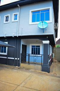 a blue house with a balcony with a frisbee on it at Jeks Apartments Limited in Ogbunike