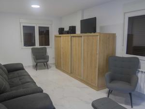 a living room with two chairs and a tv and a cabinet at Andreamar II in Cambados