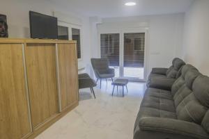 a living room with a couch and a flat screen tv at Andreamar II in Cambados