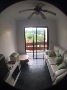 a living room with a couch and a ceiling fan at Edificio Namberuã in Guarujá