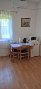 a small kitchen with a table and a microwave at Benkovac sobe in Benkovac