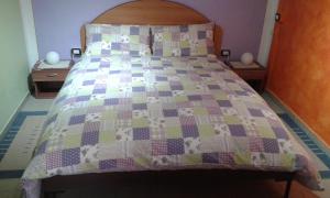 a bed with a quilt with cows on it at Vanni's House in Cannobio