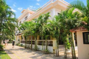 a building with palm trees in front of it at Riverside Regency Resort in Baga