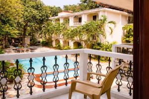 a balcony with a chair and a swimming pool at Riverside Regency Resort in Baga +9 photos