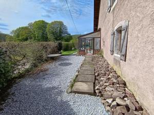 a house with a stone path next to a building at Gîte MARISA in Champagney