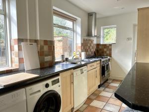 a kitchen with a washer and dryer at Large Stylish 5 bed Cambridge House in Harston