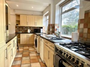 a large kitchen with a stove and a window at Large Stylish 5 bed Cambridge House in Harston