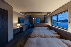 a bedroom with three beds and a large window at 中尾甚六Hotel in Karatsu