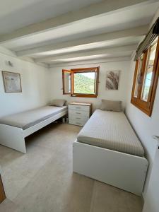 a bedroom with two beds and a window at Iris Cretan Mountain Escape in Apothíkai