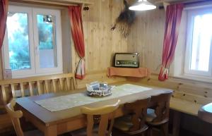 a dining room with a table and a tv at Chalet Adlerhorst am Großglockner in Heiligenblut