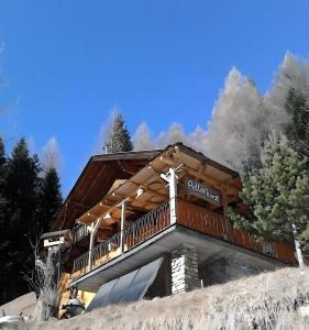 a log cabin on top of a hill with trees at Chalet Adlerhorst am Großglockner in Heiligenblut