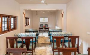 a dining room with chairs and a table at Citadel Boutique Hotel in Thekkady +7 photos