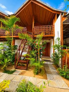 a house with a wooden staircase in front of it at Beach Wave Hotel in Arugam Bay +12 photos