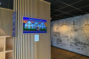 a wall with a picture of a house on it at Giethoorn Old Art Hotel in Giethoorn