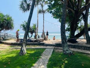 a group of people on a beach with palm trees at Villa Flamingo in Ahangama +22 photos