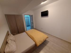 a small bedroom with a bed and a television at Apartament Dem Radulescu Bloc nou! in Râmnicu Vâlcea