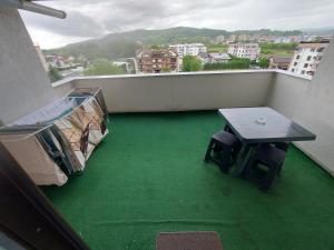 a balcony with a table and a green floor at Apartament Dem Radulescu Bloc nou! in Râmnicu Vâlcea