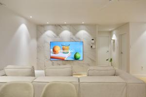 a living room with a couch and a tv on a wall at soul stay in Busan