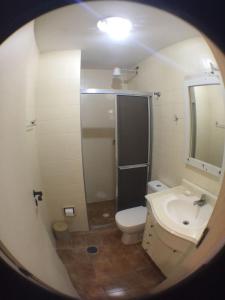 a small bathroom with a toilet and a sink at Edificio Namberuã in Guarujá