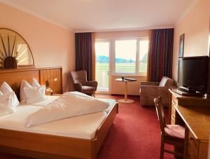 ein Hotelzimmer mit Bett und Fernseher in der Unterkunft Hotel Pachernighof in Velden am Wörthersee