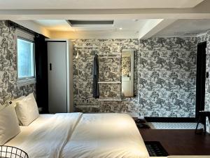 a bedroom with a bed and a wall with wallpaper at Hotel Le'O in Seoul