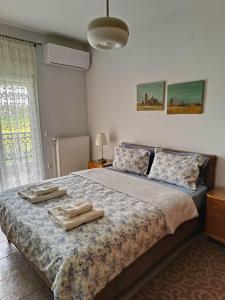 a bedroom with a bed with two towels on it at Polys Apartment and Paraskevi studio with view in Ptolemaida