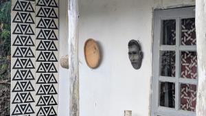 a wall with a mask next to a window at ImuHira Campsite in Nyamasheke