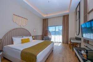 a hotel room with a bed and a flat screen tv at Royal Atlantis Icon in Side