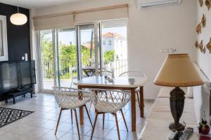 a living room with a table and chairs and a television at Marilia GuestHouse - Seaside Retreat in Evia in Agia Anna