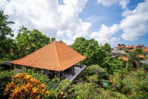 an orange roof on a house with trees at Bismajaya Bungalow in Ubud