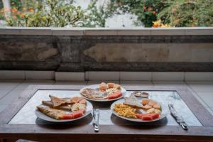 a table with two plates of food on a table at Bismajaya Bungalow in Ubud