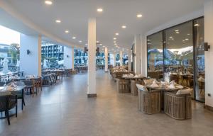 a dining room with tables and chairs in a restaurant at Royal Atlantis Icon in Side